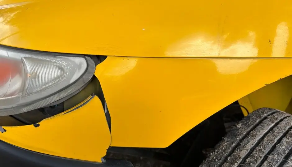Mécanicien qui écoute un bruit sous une voiture sur un pont élévateur